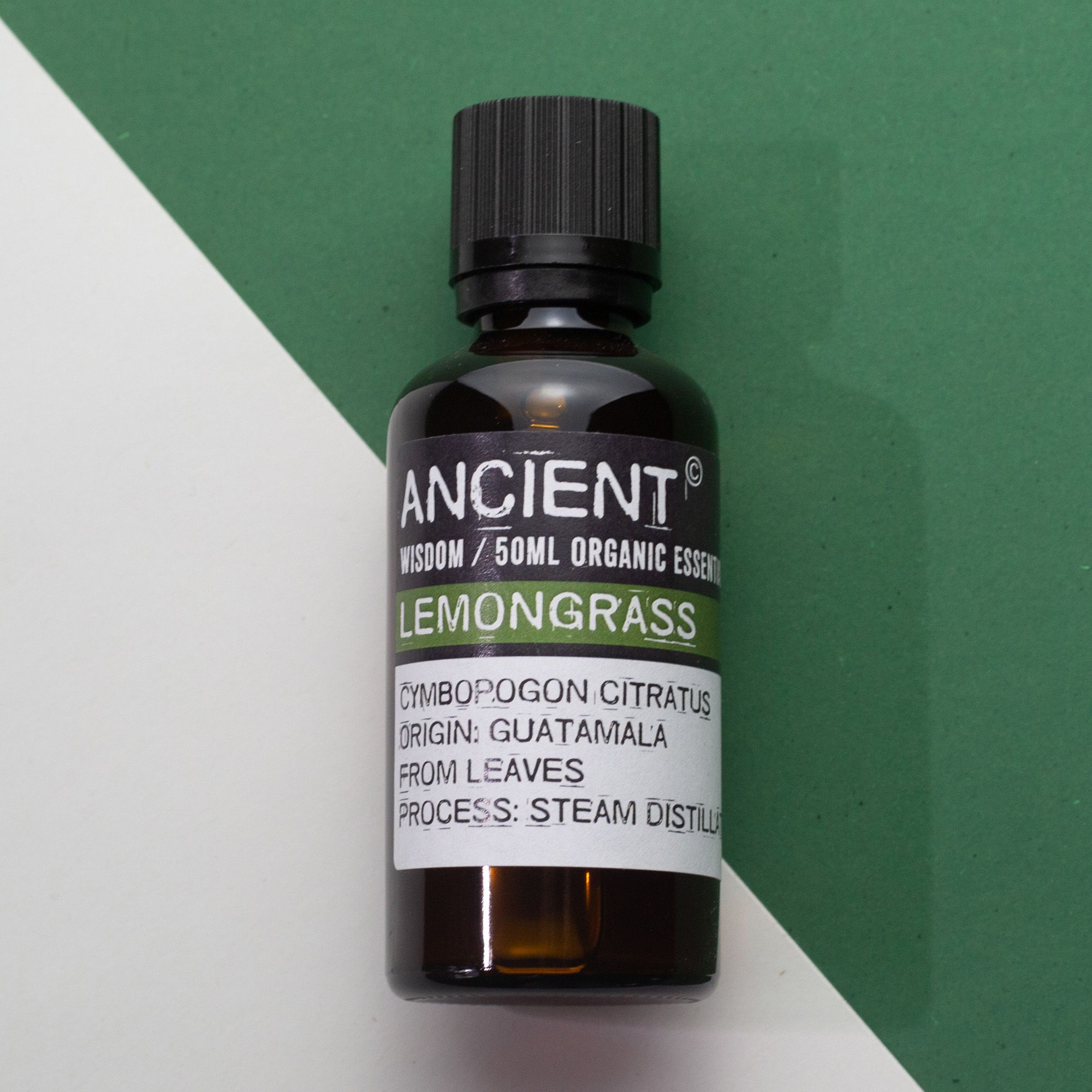 Frasco de aceite esencial orgánico de hierba limón 50 ml sobre fondo blanco y verde.