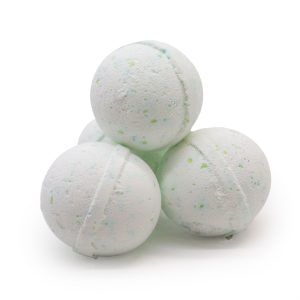 Tres bombas de baño claras con pequeñas motas verdes sobre fondo blanco correspondiente a bomba de baño con poción antiestrés.