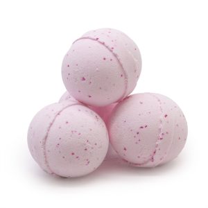 Tres bombas de baño rosadas con pequeñas motas correspondiente a bomba de baño con poción pasión.