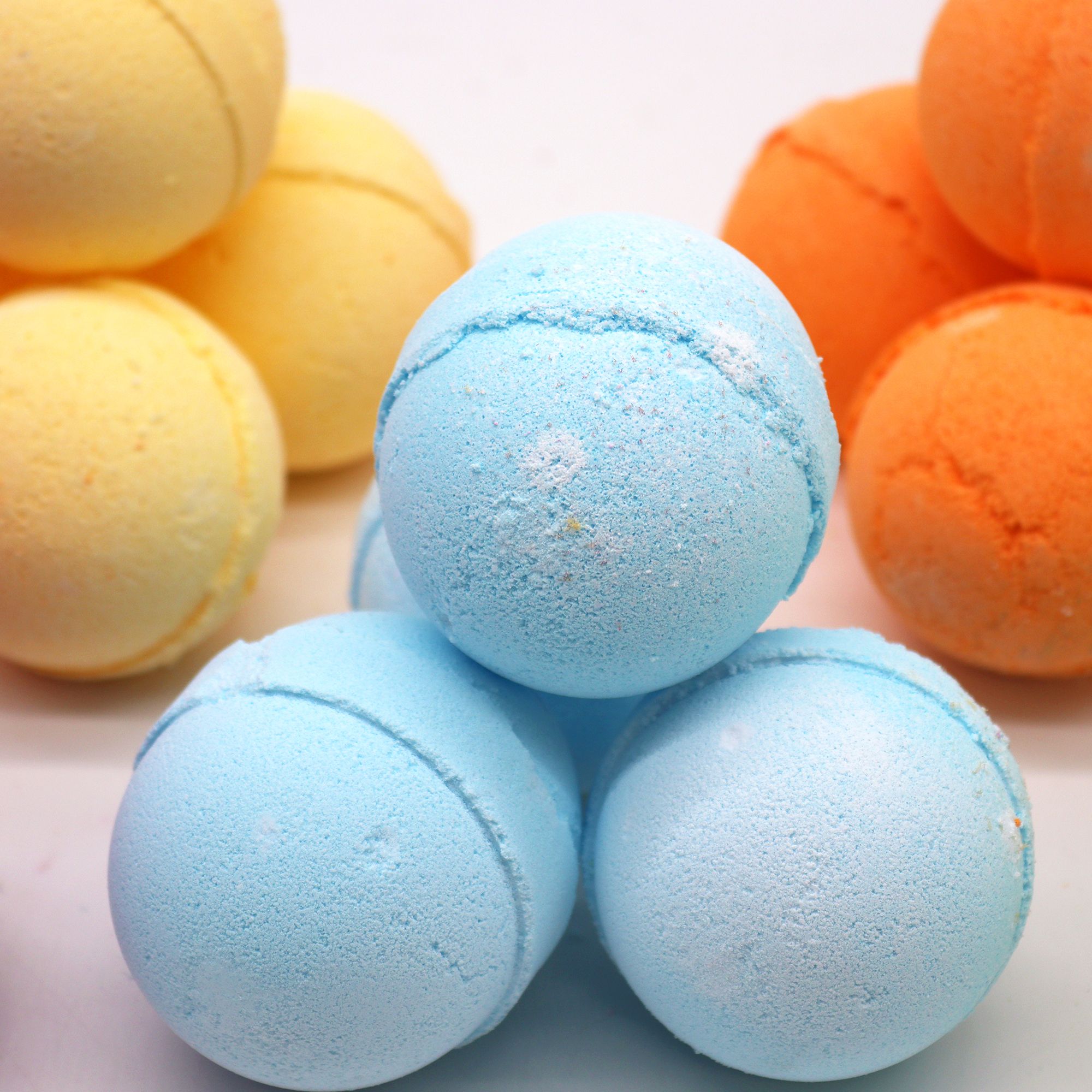 Conjunto de bombas de baño azules, con tres en primer plano correspondiente a bomba de baño lavanda y mejorana.