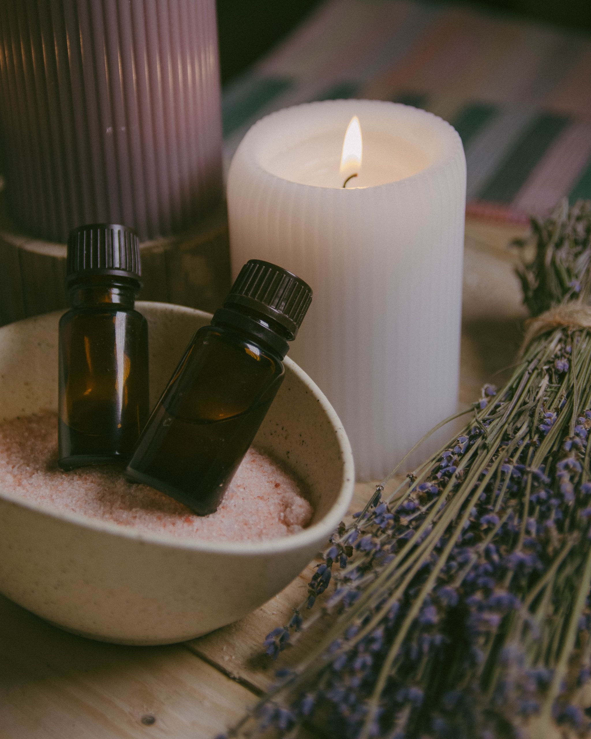 
Primer plano de aceites esenciales, velas y lavanda para crear un ambiente relajante de spa.