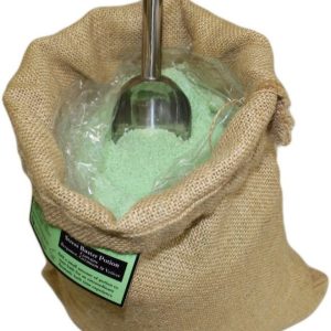 Poción de baño de aromaterapia Anti-Stress en un saco abierto con sales de tono verde claro y cuchara.