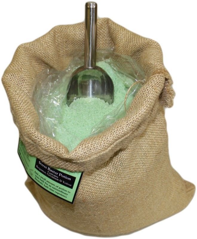 Poción de baño de aromaterapia Anti-Stress en un saco abierto con sales de tono verde claro y cuchara.