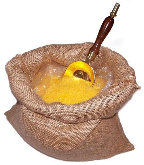 Saco abierto con la poción de baño Estimulante, sales amarillas y cuchara metálica.
