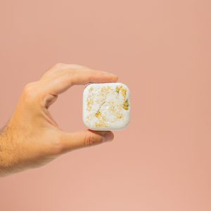 Una mano sostiene un vaporizador de ducha de aromaterapia en forma de cubo de la variante Calmante.